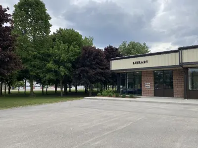 photograph of front of building labelled library, big windows and a library mail slot