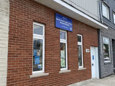 Front of library, red brick buidling, three windows and white door